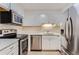 Modern kitchen with stainless steel appliances, white cabinets and backsplash, perfect for cooking and entertaining at 3315 S Ammons St # 103, Lakewood, CO 80227