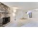 Spacious living room with a stone fireplace, neutral carpet, and open access to the kitchen at 3315 S Ammons St # 103, Lakewood, CO 80227