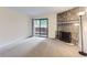 Bright living room with a stone fireplace, sliding glass door and neutral carpet at 3315 S Ammons St # 103, Lakewood, CO 80227