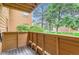 Outdoor patio with wood railing, providing a peaceful view of the surrounding greenery and trees at 3315 S Ammons St # 103, Lakewood, CO 80227