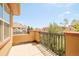 This balcony has wrought iron railings with views of neighboring homes and landscaping at 7777 E 23Rd Ave # 1401, Denver, CO 80238