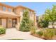 Tan two-story townhome featuring a tile roof, neutral trim, private entrance and lovely landscaping at 7777 E 23Rd Ave # 1401, Denver, CO 80238