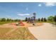 A playground with slides, climbing structures, and mature trees at 7777 E 23Rd Ave # 1401, Denver, CO 80238