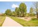 A neighborhood playground with mature trees and a sidewalk at 7777 E 23Rd Ave # 1401, Denver, CO 80238