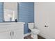 Clean and modern bathroom with white vanity and blue shiplap walls at 3955 W 13Th Ave, Denver, CO 80204