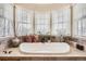 Bright bathroom featuring a soaking tub under three large windows and tile surround at 76 S Garfield St, Denver, CO 80209