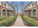 Beautifully landscaped courtyard with brick pathways, lush greenery, and charming Tudor-style townhomes at 76 S Garfield St, Denver, CO 80209