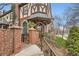 Inviting brick entrance with iron gate leads to a charming Tudor-style townhome with manicured landscaping at 76 S Garfield St, Denver, CO 80209