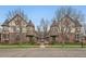 Charming Tudor-style townhomes feature brick and stucco exteriors, accented by mature trees and manicured landscaping at 76 S Garfield St, Denver, CO 80209