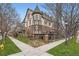 Elegant townhome showcases Tudor architecture, private balconies, iron railings, and lush landscaping on a sunny corner lot at 76 S Garfield St, Denver, CO 80209