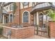 Charming brick-paved front porch with iron gate and seating area for relaxing at 76 S Garfield St, Denver, CO 80209