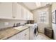 Well-lit laundry room with modern washer and dryer, cabinets, and ample counter space at 76 S Garfield St, Denver, CO 80209