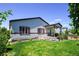 Well-maintained backyard with lush lawn, covered patio, and decorative landscaping for outdoor enjoyment at 6049 Sandstone Cir, Erie, CO 80516
