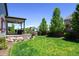 Lush backyard featuring a covered patio and well-maintained lawn at 6049 Sandstone Cir, Erie, CO 80516