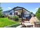 Beautiful backyard with a covered patio, dining area, lush greenery, and a storage shed at 6049 Sandstone Cir, Erie, CO 80516
