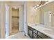 Bathroom with double sinks, lots of counter space, and a walk-in closet/storage area at 6049 Sandstone Cir, Erie, CO 80516