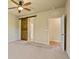 Bedroom with a rustic barn door leading to the en suite bath, and light-colored walls at 6049 Sandstone Cir, Erie, CO 80516