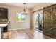 Dining area with a modern chandelier, lots of natural light, and a sliding barn door to the patio at 6049 Sandstone Cir, Erie, CO 80516