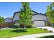 Beautifully landscaped home featuring a well-manicured lawn and a two-car garage at 6049 Sandstone Cir, Erie, CO 80516