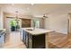 Bright kitchen showcasing a large island, modern lighting, and a sliding barn door to the outdoor patio at 6049 Sandstone Cir, Erie, CO 80516