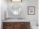 Bathroom features a wood vanity with stone countertop, round mirror and decorative lighting at 1700 Bassett St # 1803, Denver, CO 80202