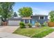 Charming gray two-story home featuring solar panels and a bright blue front door at 9275 W Euclid Ave, Littleton, CO 80123