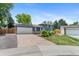 A two-story gray home with solar panels and a well-maintained lawn on a clear day at 9275 W Euclid Ave, Littleton, CO 80123