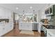 Well-lit kitchen featuring white cabinets, stainless steel appliances, and hardwood floors at 9275 W Euclid Ave, Littleton, CO 80123