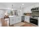 Modern kitchen featuring white cabinets, quartz countertops, stainless steel appliances, and an open floor plan at 9275 W Euclid Ave, Littleton, CO 80123