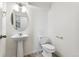 Bright half bathroom featuring a pedestal sink, oval mirror, and modern fixtures at 28621 E 8Th St, Watkins, CO 80137