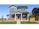 Charming two-story home featuring a red door and stone accents, set on a well-maintained lawn at 28621 E 8Th St, Watkins, CO 80137
