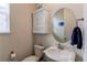 Charming powder room featuring a pedestal sink, decorative mirror, and classic fixtures at 8204 S Vandriver Way, Aurora, CO 80016