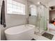 Bright bathroom features soaking tub with white marble tile surround, and a walk-in shower with glass door at 8204 S Vandriver Way, Aurora, CO 80016