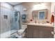 Bathroom with a glass door shower, gray vanity, and a gray tiled shower at 8204 S Vandriver Way, Aurora, CO 80016