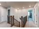 Upstairs hallway featuring a carpeted floor and wood railing leading to the various bedrooms and bathrooms at 8204 S Vandriver Way, Aurora, CO 80016