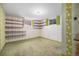 Basement area featuring built in shelving and bright green carpet at 8675 W 60Th Ave, Arvada, CO 80004