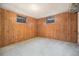This basement features wood paneling and two small windows at 8675 W 60Th Ave, Arvada, CO 80004