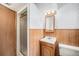 Bathroom with wood paneling, shower stall, and single sink at 8675 W 60Th Ave, Arvada, CO 80004
