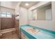 Retro bathroom with a turquoise sink and countertop, complemented by a vintage tiled shower and unique fixtures at 8675 W 60Th Ave, Arvada, CO 80004
