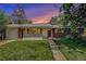 Charming brick home with white trim, a well-manicured lawn, and a cozy, inviting curb appeal at sunset at 8675 W 60Th Ave, Arvada, CO 80004