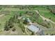 Panoramic aerial view of property with metal outbuilding surrounded by lush greenery, mature trees, and long driveway at 1549 Hillside Cir, Sedalia, CO 80135