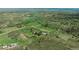 Expansive aerial view of the property on rolling green hills surrounded by trees and farmland at 1549 Hillside Cir, Sedalia, CO 80135