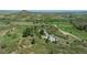Gorgeous aerial view of the property on rolling green hills with mountain views in the distance at 1549 Hillside Cir, Sedalia, CO 80135