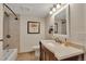Bathroom featuring a vanity, framed mirror, and tiled shower and tub surround at 1549 Hillside Cir, Sedalia, CO 80135