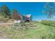 Exterior view of a multi-story home with a pond, well-manicured landscaping, and a two car garage at 1549 Hillside Cir, Sedalia, CO 80135