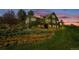 Stunning multi-level home featuring a beautifully landscaped yard with a charming water feature at twilight at 1549 Hillside Cir, Sedalia, CO 80135