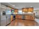 Kitchen featuring stainless steel appliances, wood cabinets, granite countertops, and wood-look tile floors at 1549 Hillside Cir, Sedalia, CO 80135