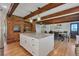 Charming kitchen boasts exposed brick, wood beams, granite counters, and stainless appliances at 1549 Hillside Cir, Sedalia, CO 80135