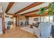 Bright living room with wood-beamed ceilings, a brick fireplace, and an open floorplan at 1549 Hillside Cir, Sedalia, CO 80135
