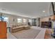 Bright living room with a sectional sofa, area rug, and a dark wood piano and brick fireplace at 1549 Hillside Cir, Sedalia, CO 80135